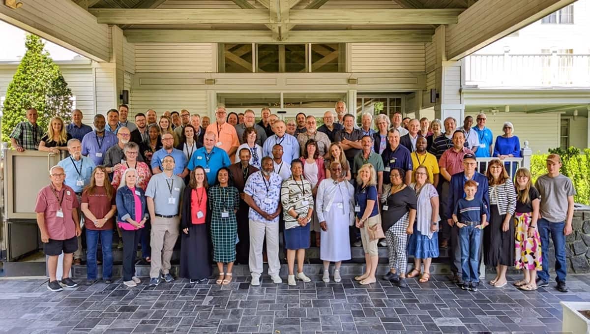 GRMF Conference 2024 attendees posed together under a covered entrance in Durham, North Carolina