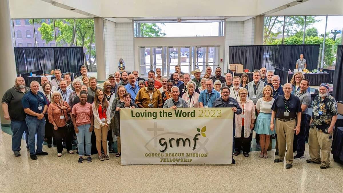GRMF Conference 2023 attendees behind a "Loving the Word 2023" banner in Sioux City, Iowa