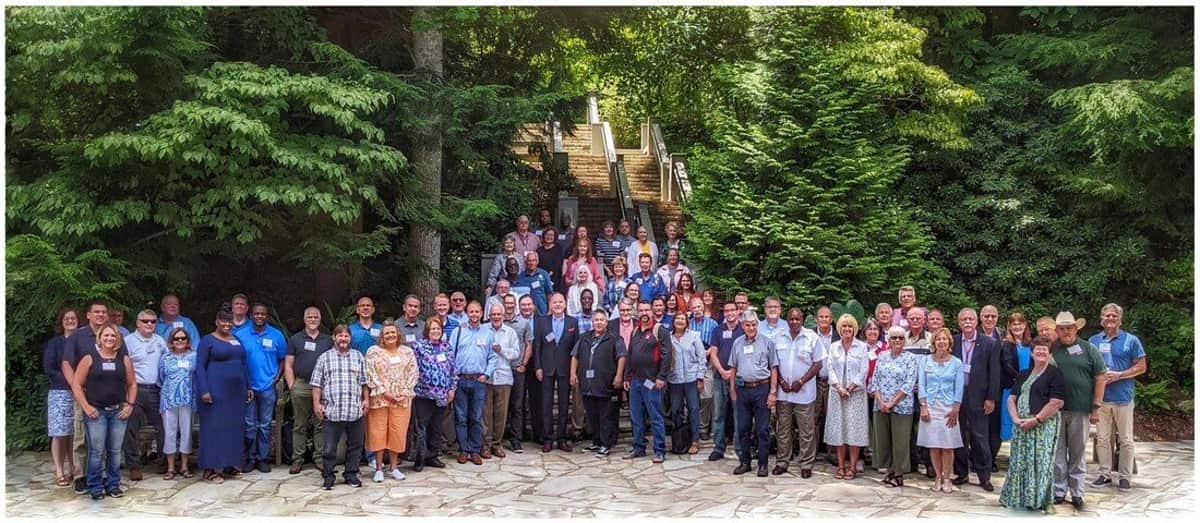 GRMF Conference 2021 attendees standing together outdoors among tall trees in Asheville, North Carolina