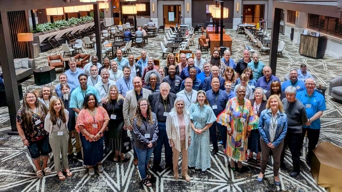 GRMF Conference 2025 attendees gathered for a group photo in a hotel atrium in Huntsville, Alabama